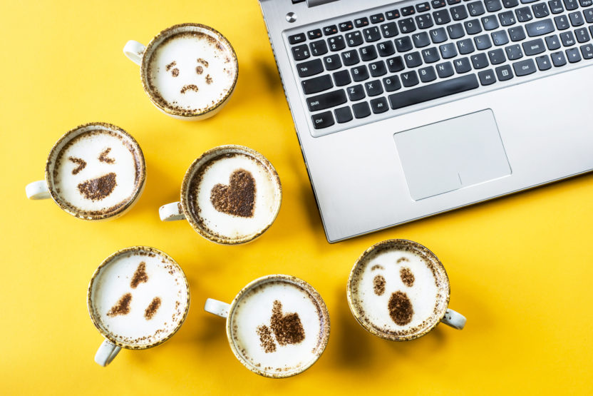 emoji on cups next to the laptop
